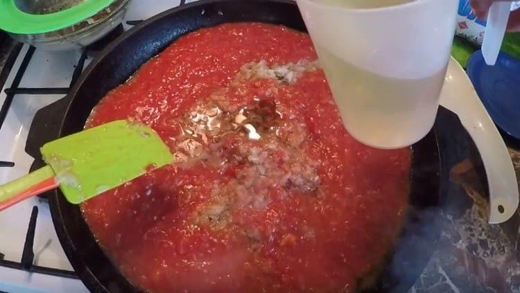 Agregue masa de tomate a la cebolla, así como también aceite vegetal.