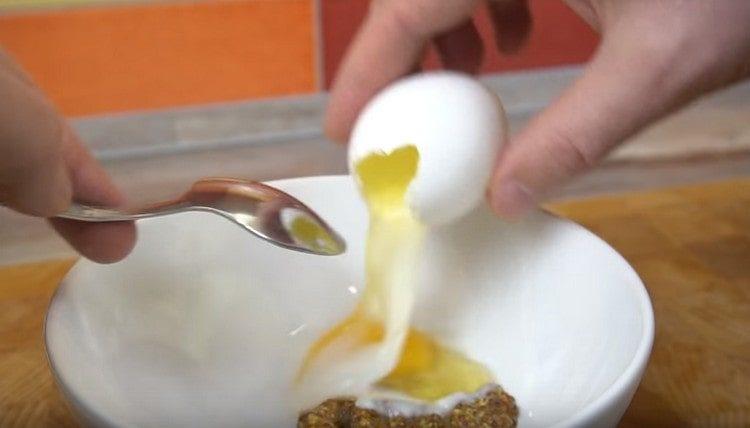 Vierte el huevo en un tazón con mostaza Dijon.