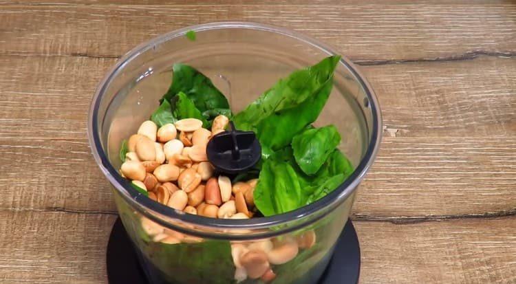 Put peanuts and basil leaves in a blender.