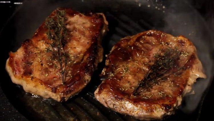 put thyme on each steak.