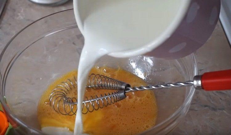 Pour part of the milk into the egg mass.