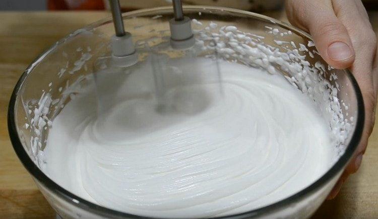 Batir la crema agria espesa con azúcar y azúcar de vainilla.