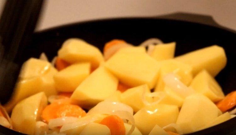 Nous répandons les pommes de terre aux légumes dans la casserole.