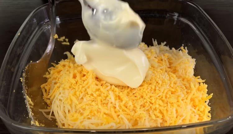Agregue mayonesa y ajo al queso con yemas.
