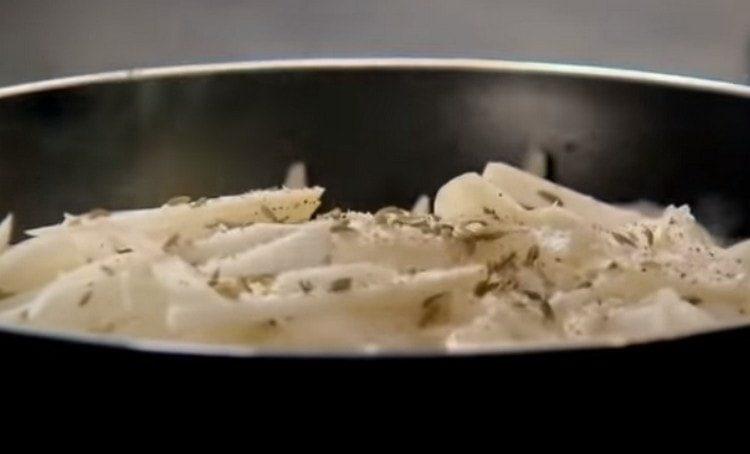 freír la cebolla en rodajas por la mitad en una sartén.