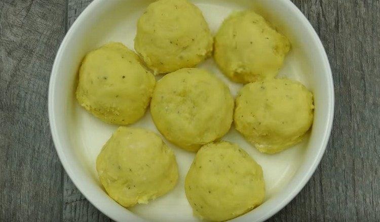 Nous mettons les boulettes de pommes de terre dans un plat graissé.