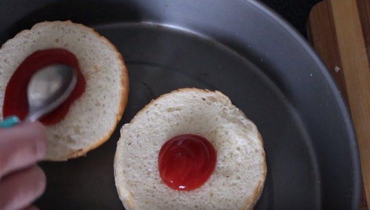 Grease the bun with ketchup.