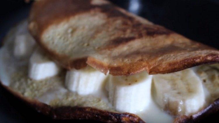 Servir la crêpe d'avoine avec du lait concentré et des tranches de banane.