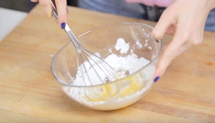 Mélangez l'oeuf avec le sucre glace et le sucre vanillé.
