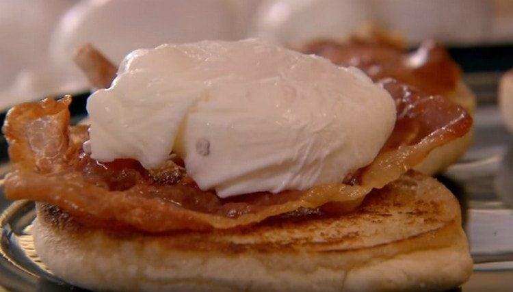 déposer des tranches de bacon sur un petit pain et des œufs de Bénédict dessus.