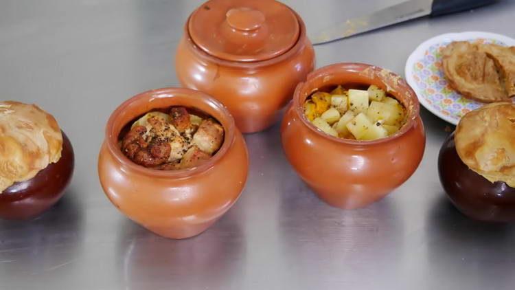 meat in pots with potatoes in the oven