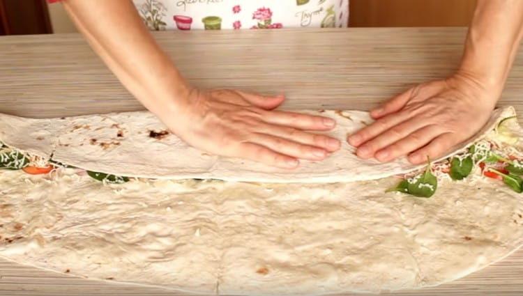 Gently roll the edges of the pita in the center. clutching them.