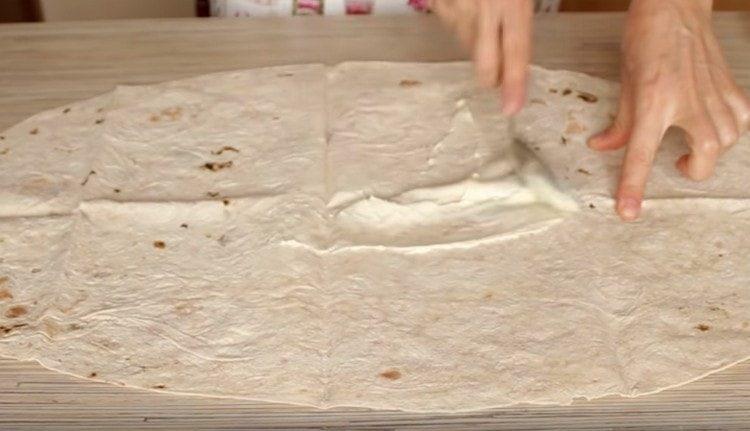 Lavash is greased with a thin layer of processed cheese.