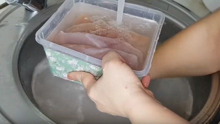 Lavez soigneusement le filet de poulet du sel, puis laissez tremper.