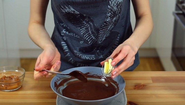 In the resulting chocolate icing, add butter, mix.