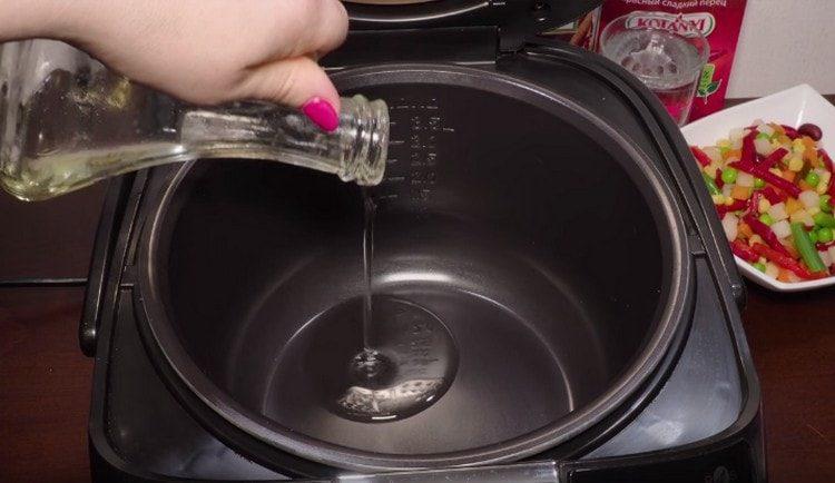 turn on the slow cooker in frying mode, pour vegetable oil into the bowl of the device.