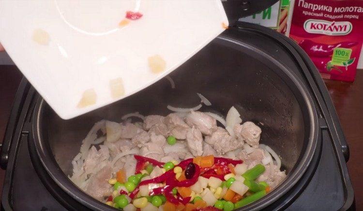 Add a mixture of frozen vegetables to the meat with onions.