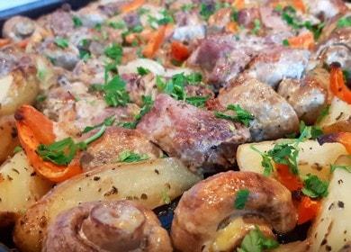 Oven with potatoes,  meat and mushrooms in the oven