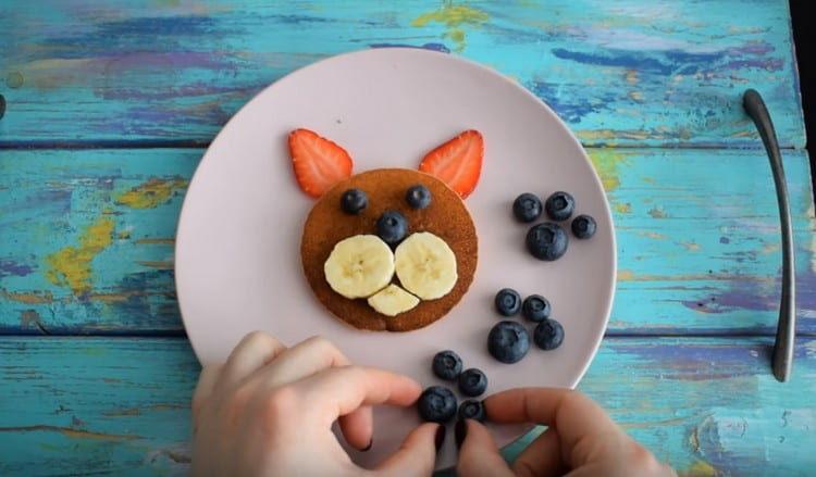 We decorate pancakes with fruit.