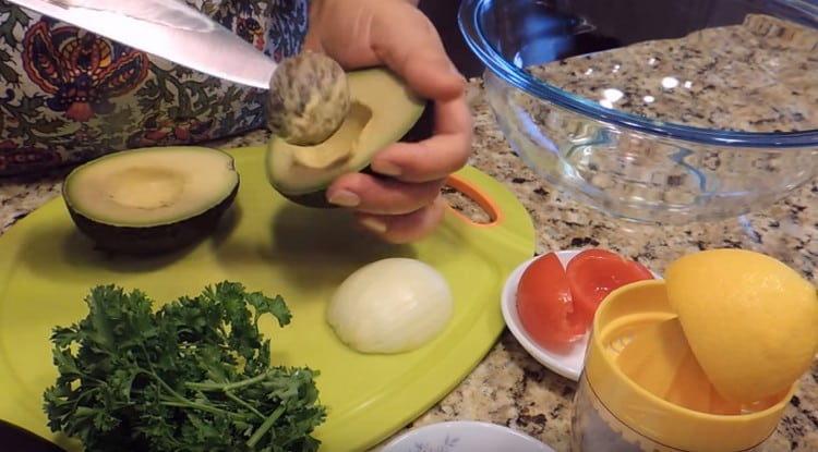 Cut the avocado in half and remove the stone.