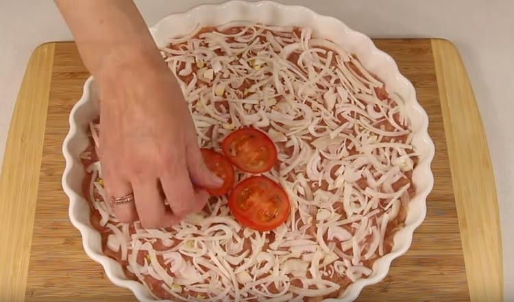 étendre l'oignon et les tomates sur la viande hachée.