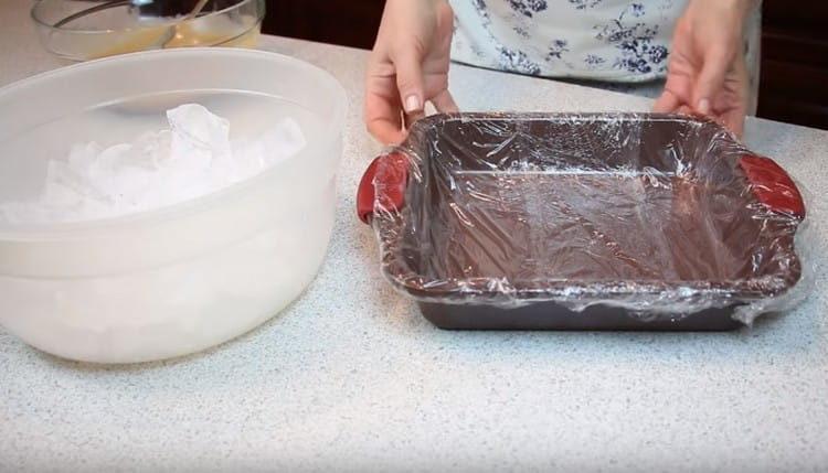 Nous recouvrons le moule à la guimauve d'un film plastique.