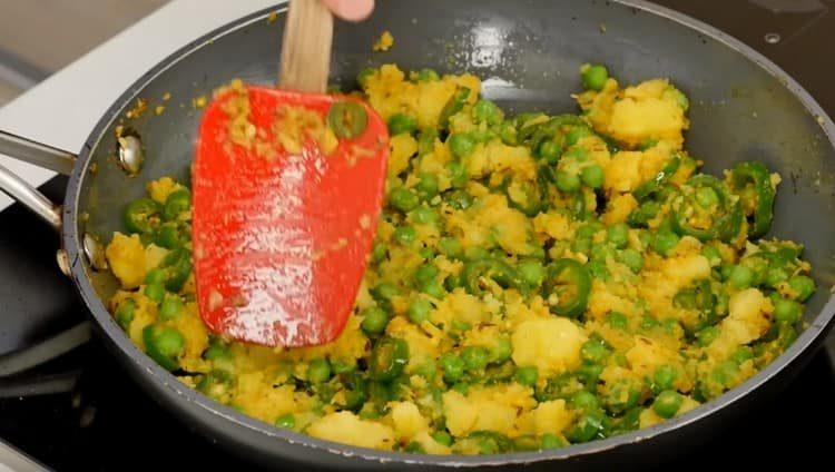 Put potatoes and peas in a pan.