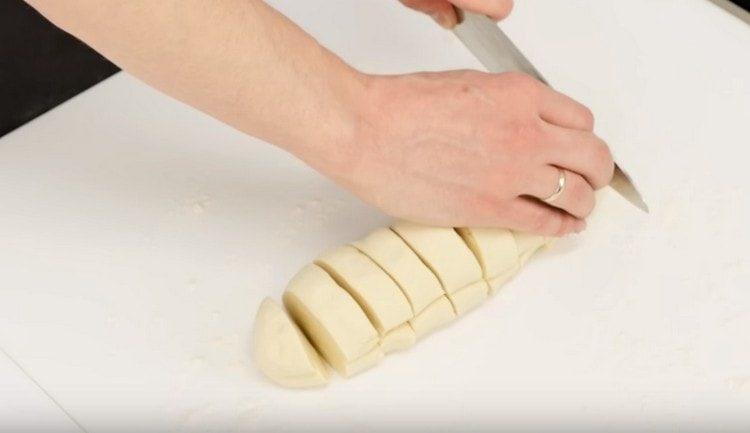 Rouler la pâte en rouleau et la couper en 8 parties.