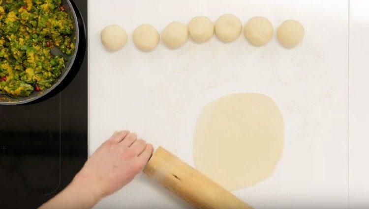 Roll out a ball from each piece of dough, then roll it out with a rolling pin.