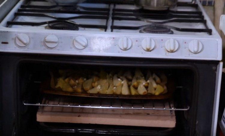 Mettez la plaque de cuisson avec les pommes de terre au four.
