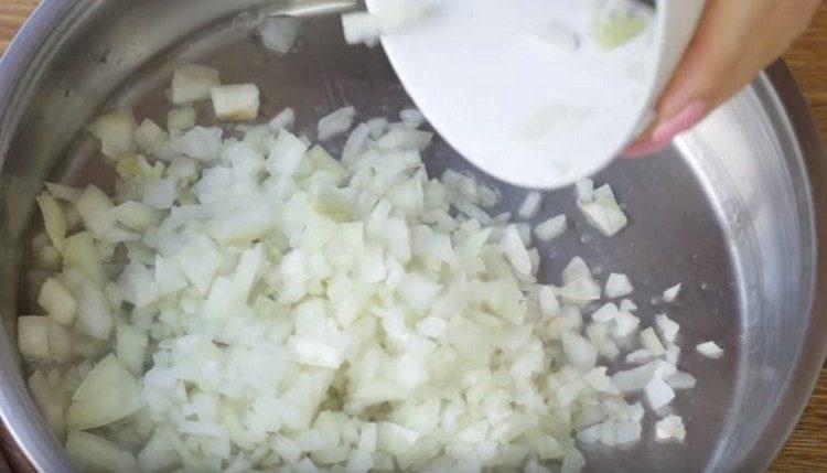 Faire frire les oignons hachés dans une poêle.