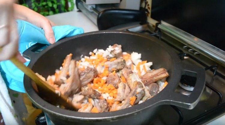 Ajoutez des carottes avec des oignons au chaudron jusqu'aux côtes.