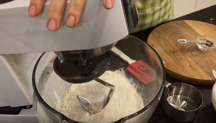 Stavite tijesto u zdjelu ili zdjelu miksera, dodajte vodu i brašno.