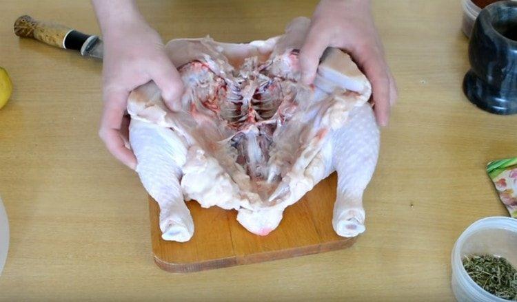 Nous découpons la carcasse de poulet en deux.