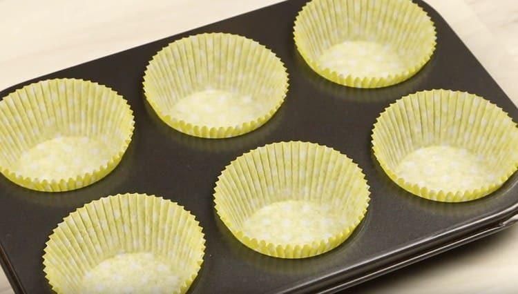 Ponemos moldes de papel especiales en moldes para muffins.