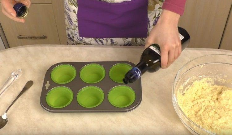 Formes pour la cuisson de muffins graisser avec de l'huile végétale.