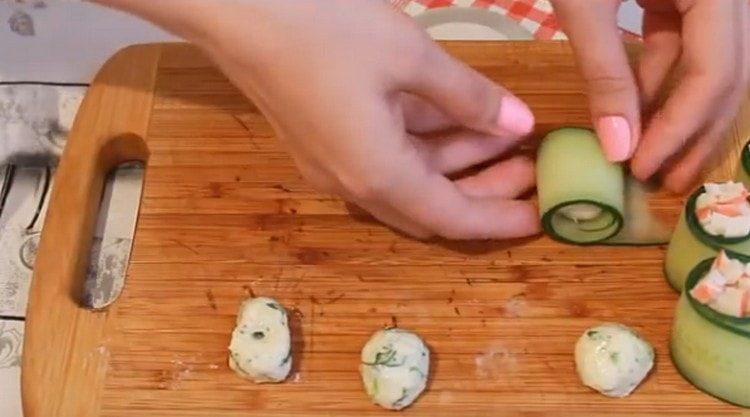 Envelopper les boulettes de fromage dans des tranches de concombre.