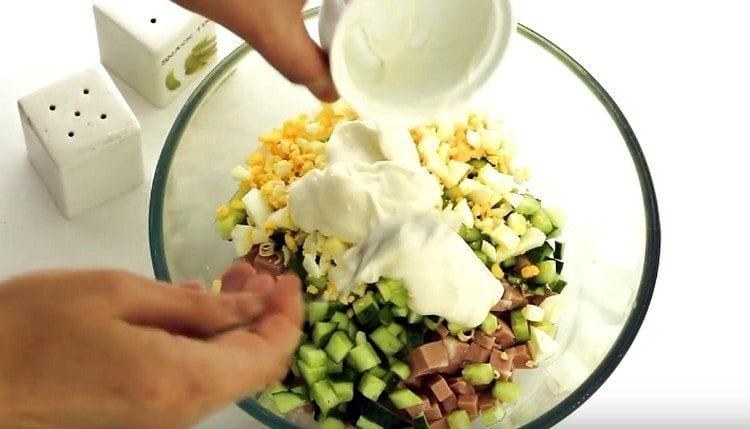 Nous combinons tous les ingrédients préparés et assaisonnons la salade avec de la mayonnaise.