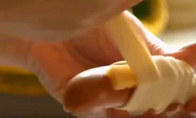 Envelopper la saucisse avec deux morceaux de fromage avec de la pâte.