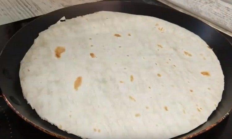 We spread the pita bread in a pan.